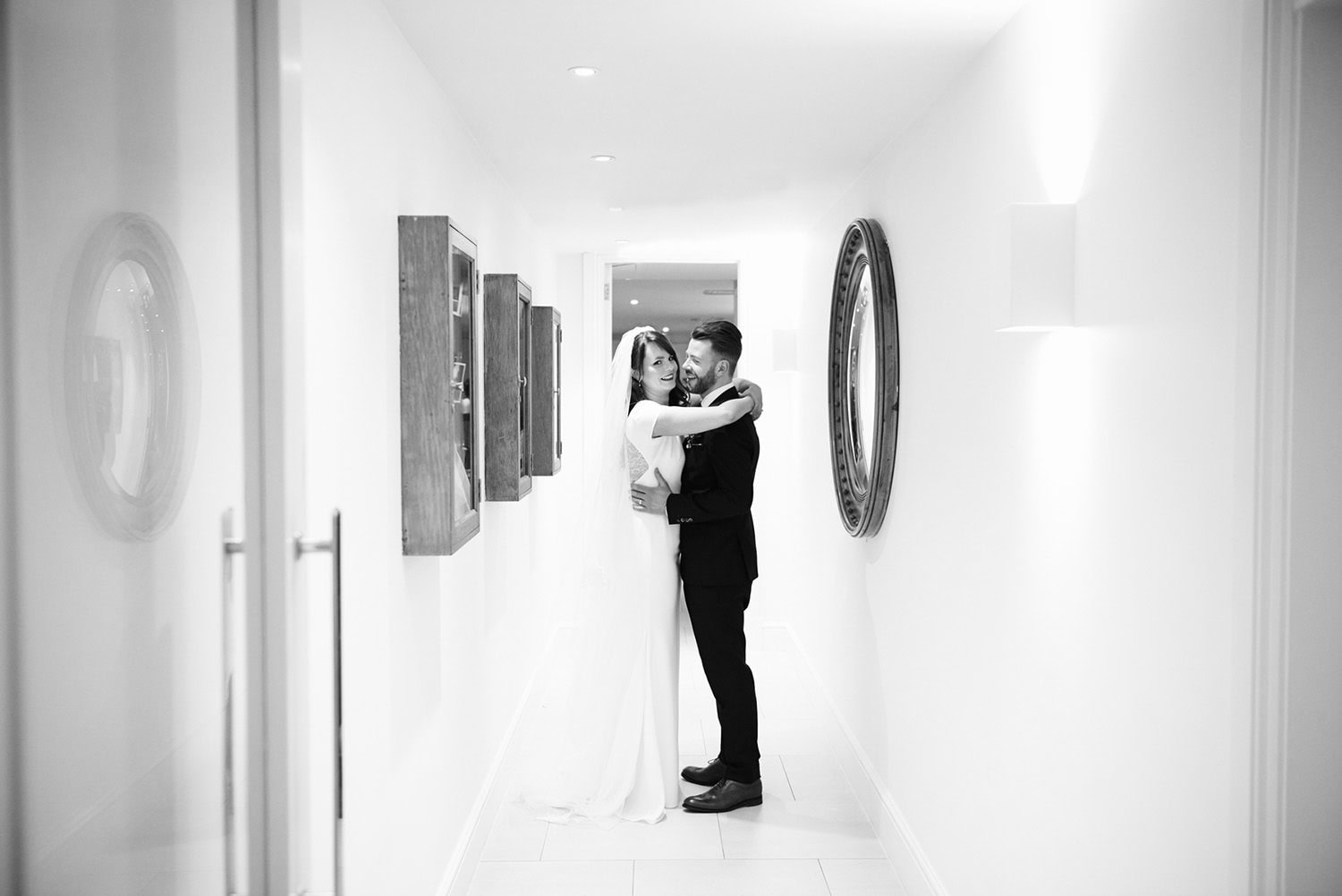bride and groom hugging in corridor inside the hotel in black and white