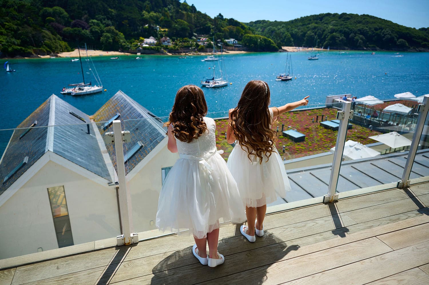 2 cute girls standing on balcony high up looking out on to the estuary and pointing