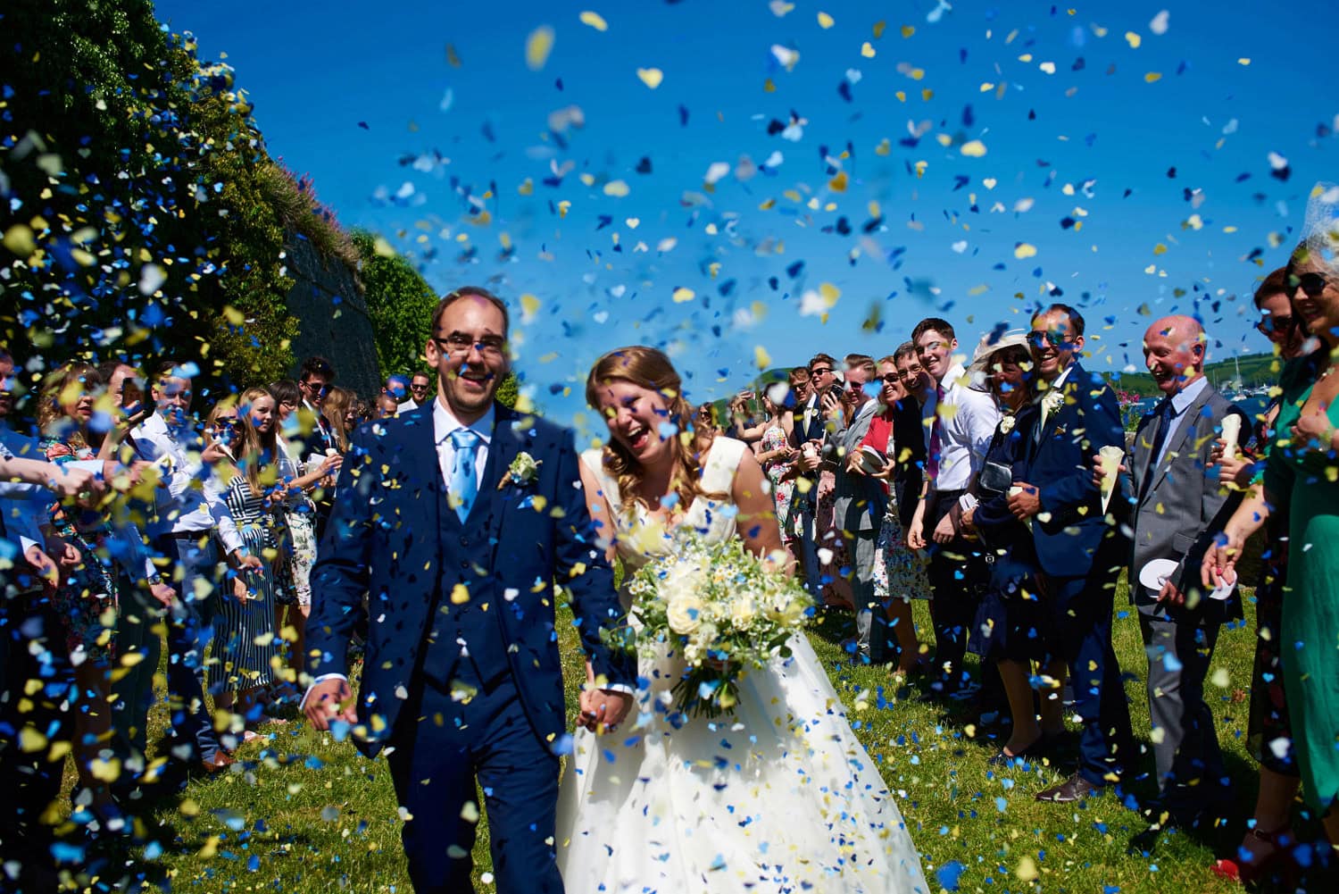 salcombe harbour hotel wedding in devon with bride and groom in complete laugher as they get covered in confetti