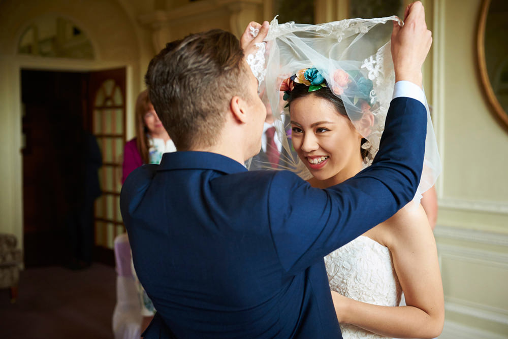 groom lifting veil of bride