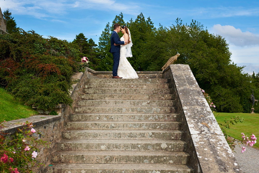 bride and groom at top of stairs outside