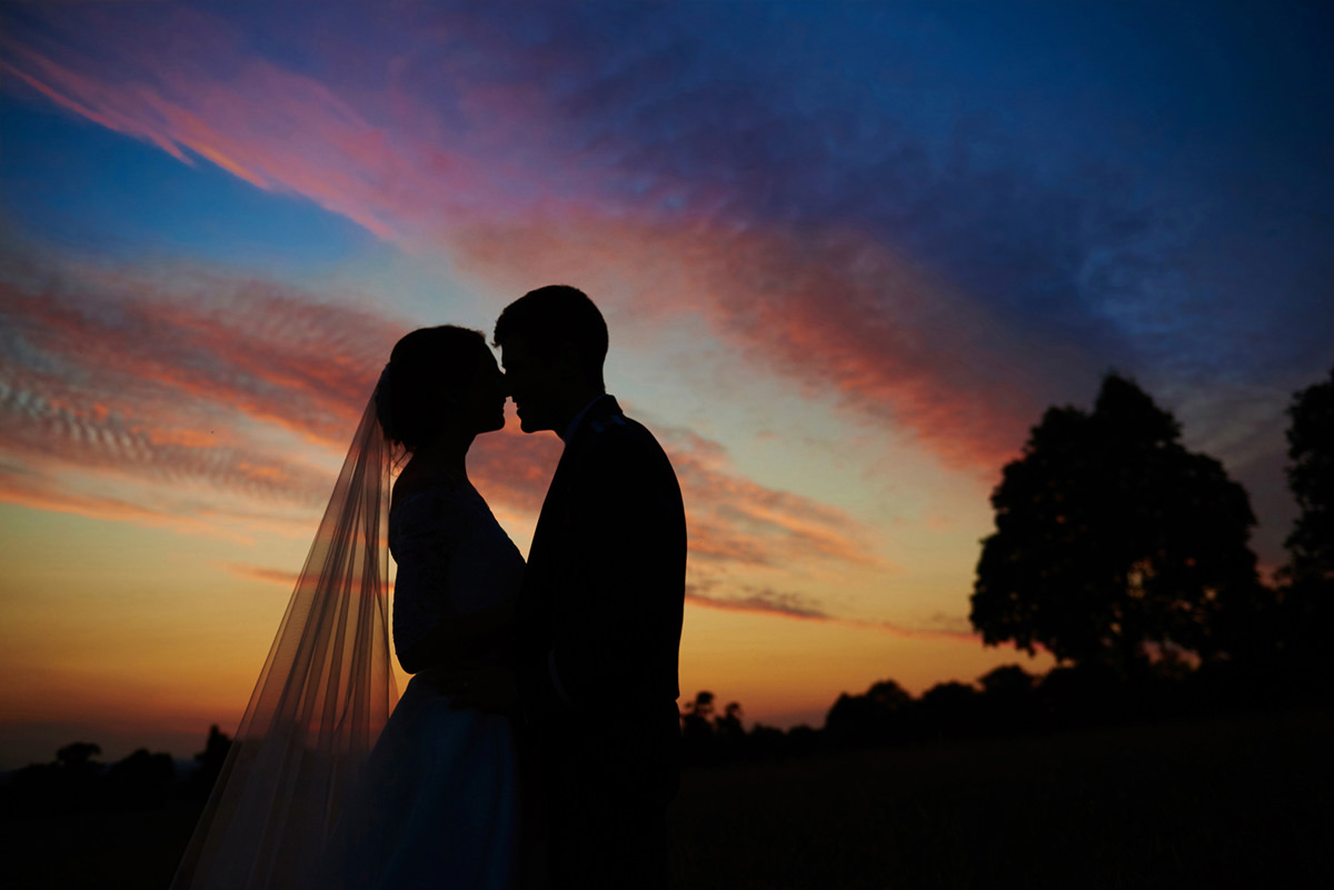 Sunset with bride and groom silhouette and beautiful sky at Rockbeare Manor in Devon