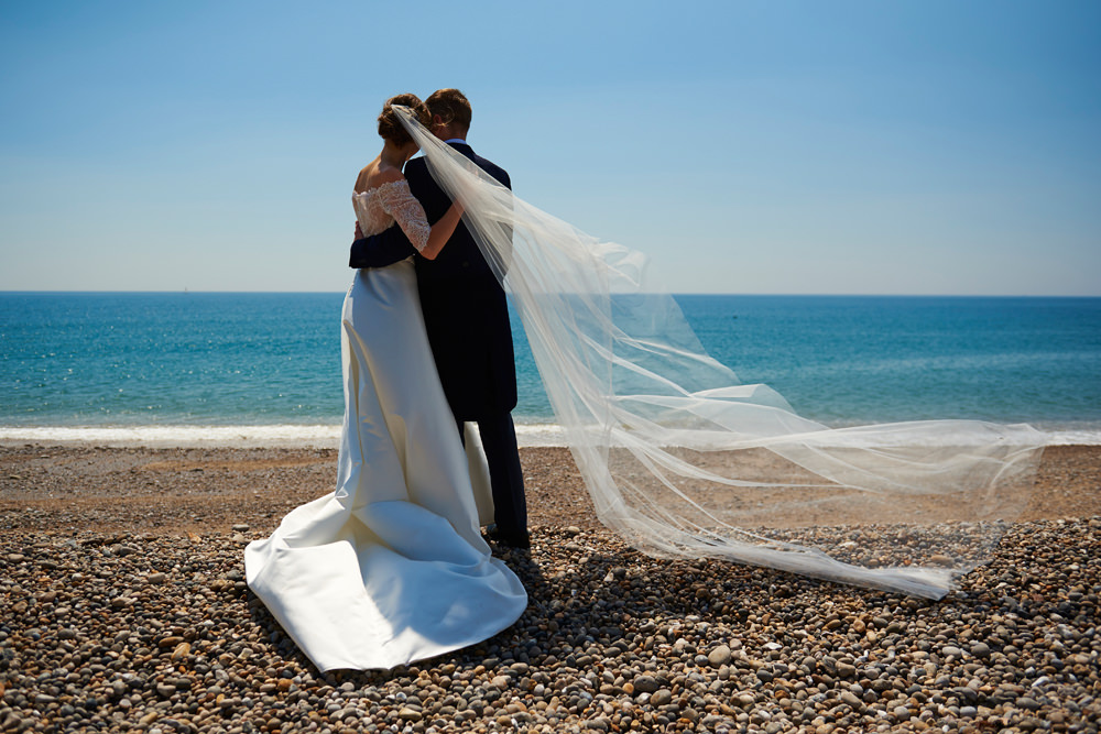 bride and groom and veil and sea