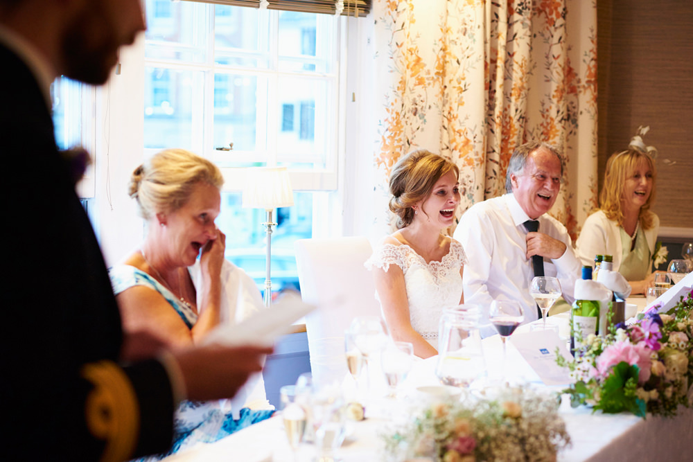grooms speech with bride and parents laughing