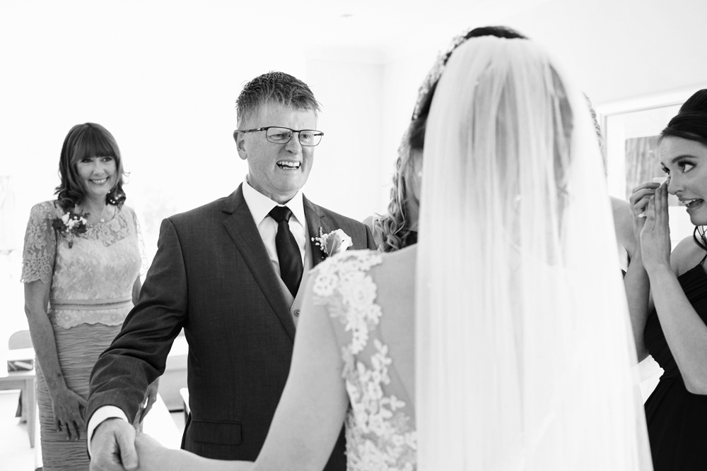 father of bride seeing daughter in her dress for the first time