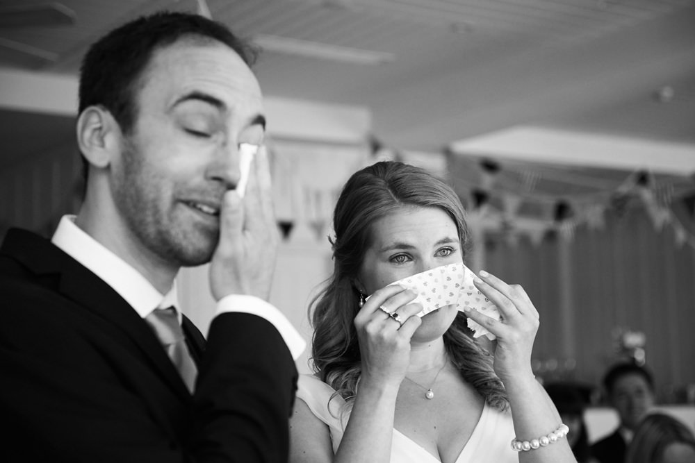bride and groom both crying during ceremony with tissues