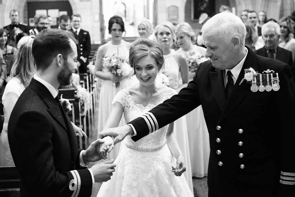 navy father of bride handing daughter over to navy groom in dartmouth