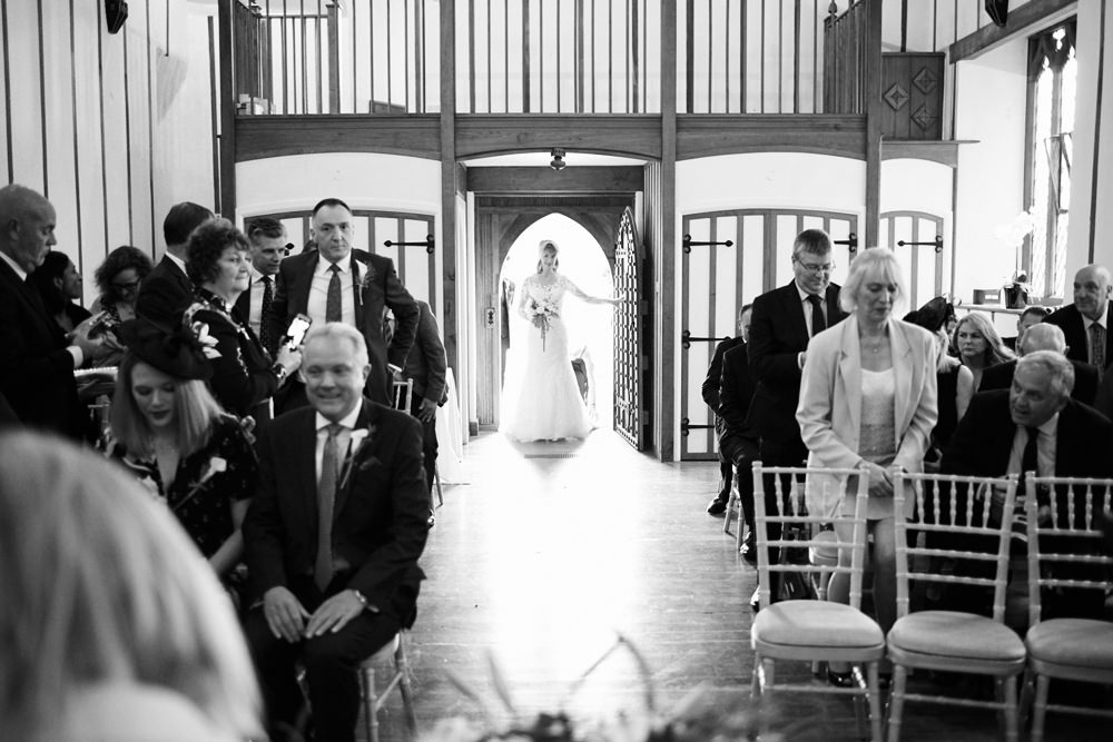 entrance of bride into chapel with sun lighting her from behind