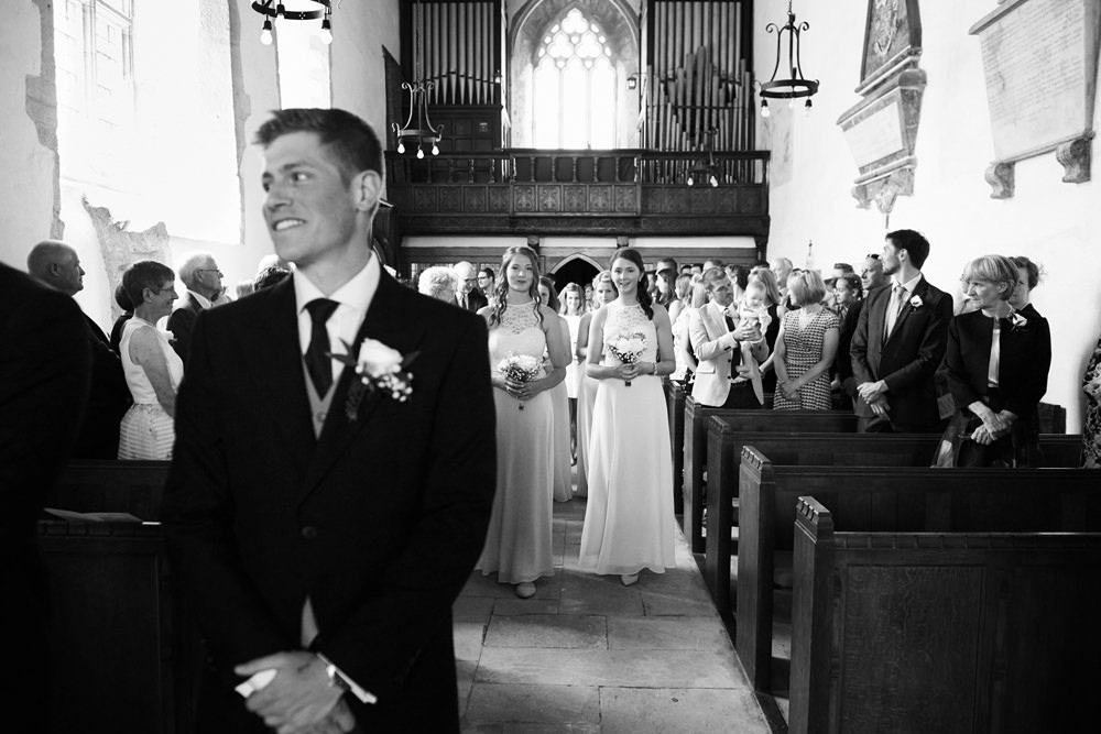 groom anticipating brides entrance at church ceremony