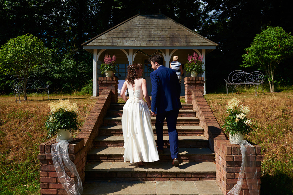 bride and groom walking up to the summer house