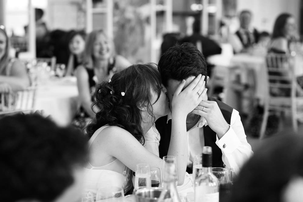 bride kissing groom gently during speech