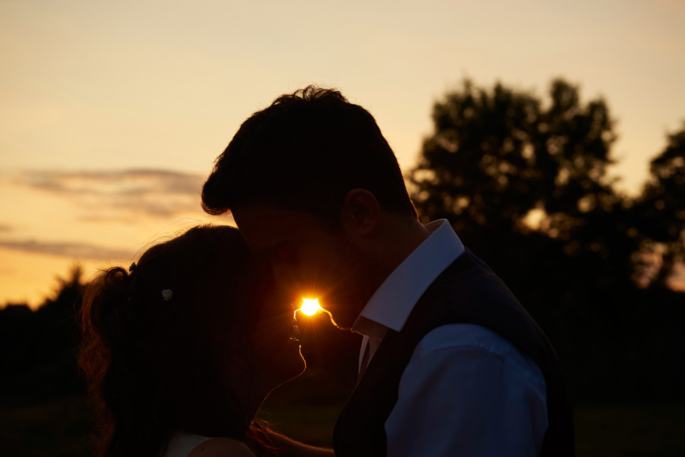 sunset shot with silhouette with bride and groom