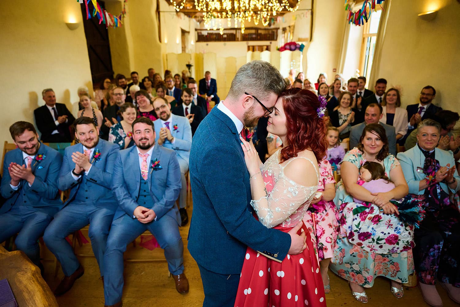 Corn Barn wedding, bride and groom embarcing after just getting married inside the colourful barn